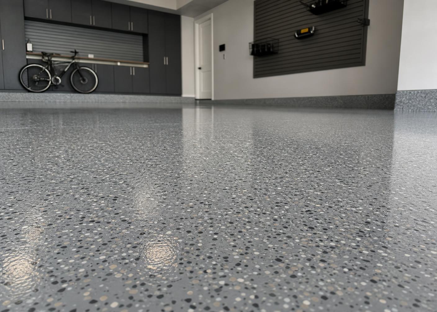 Professionally installed polyaspartic flake floor coating in a clean residential garage — seamless, glossy, durable finish